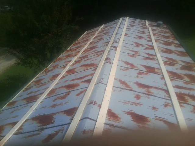 Rusted metal roof panels with new wood purlins before replacement — Storm Damage Roof Repair in Bunch by Roofing Brothers