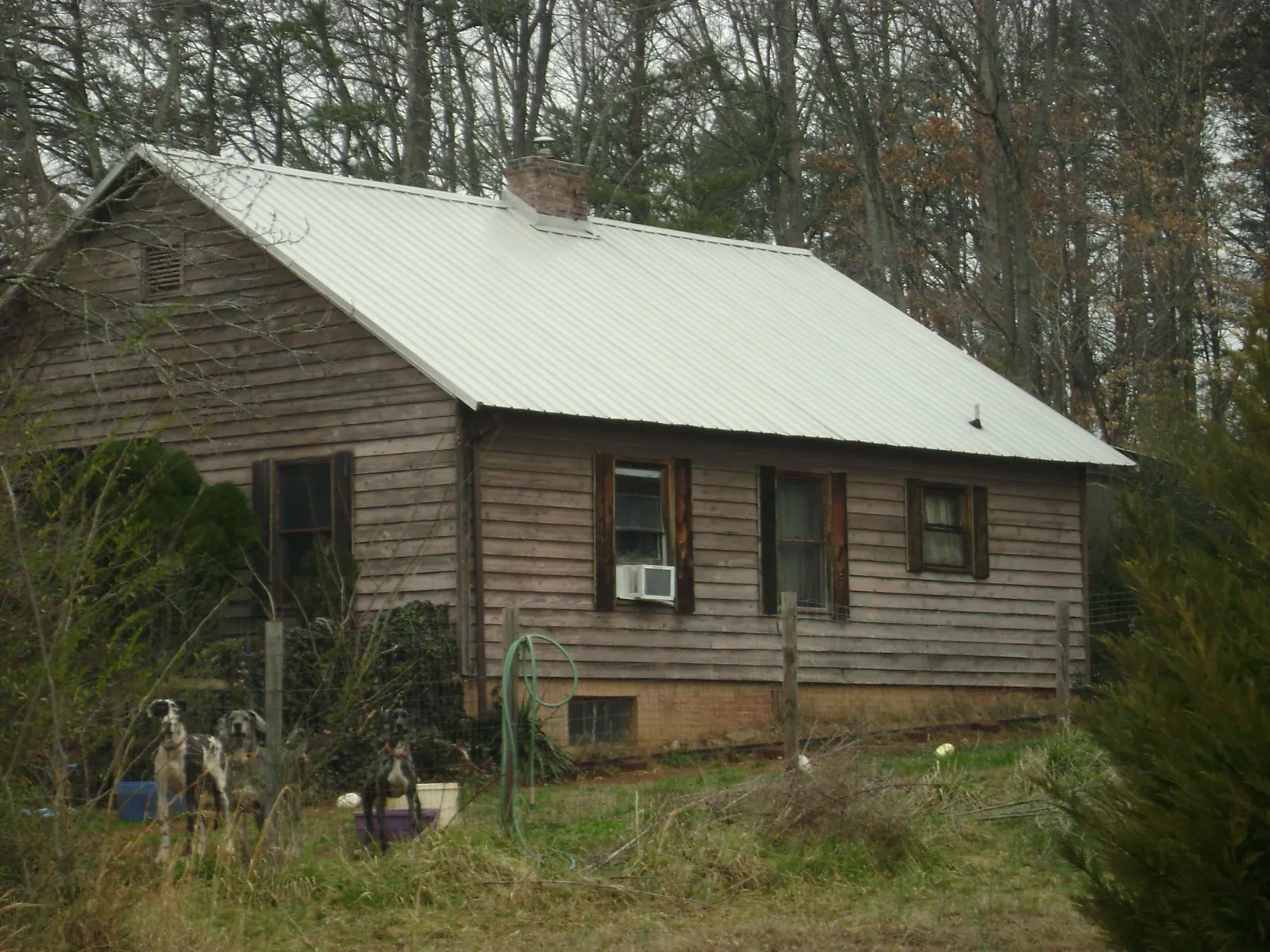 White metal roof on an old wood sided farmhouse, from a Metal Roof Installation job in Bunch